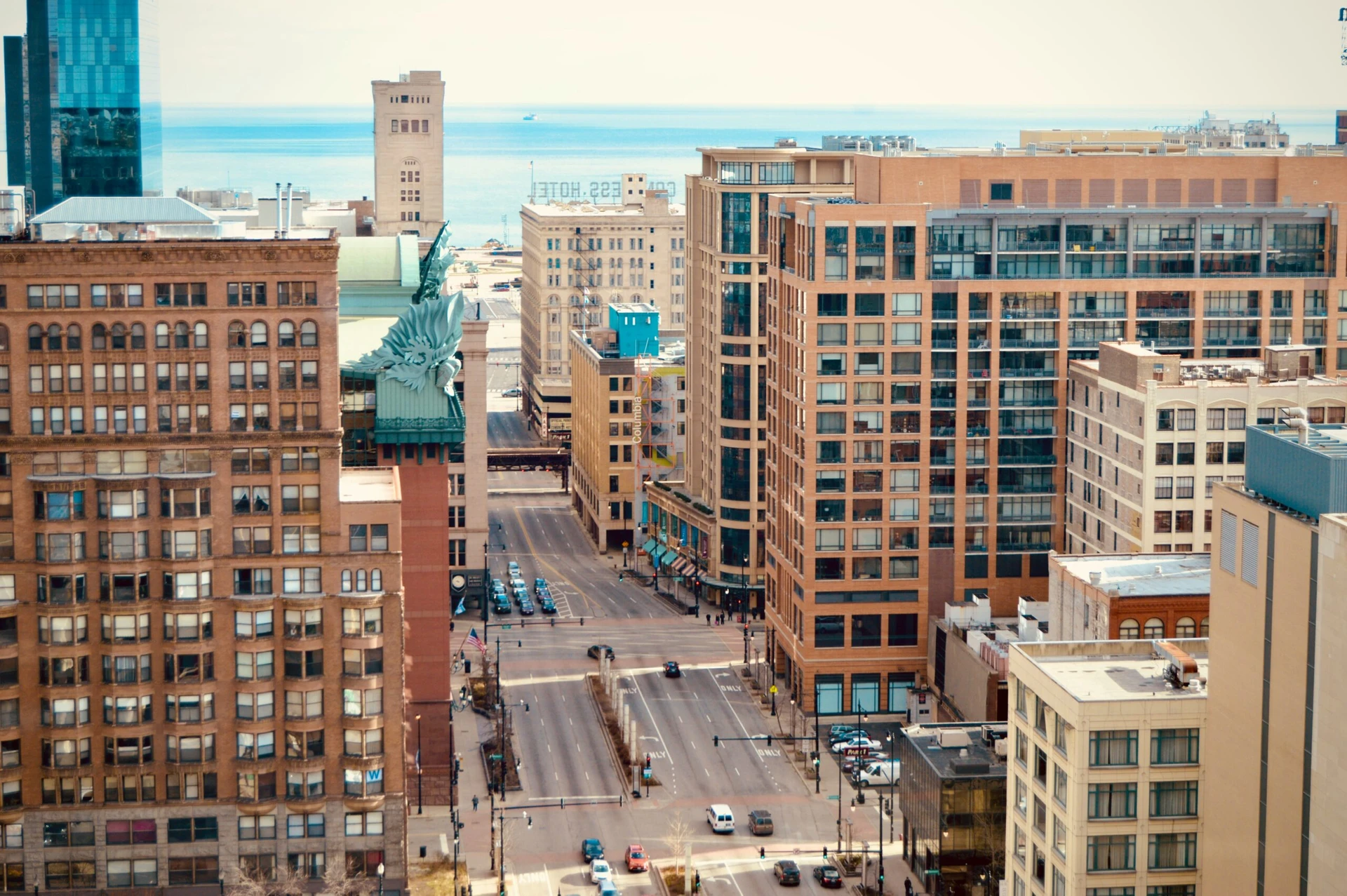 Elevated view of a downtown street lined with mid- and high-rise buildings on a clear day.